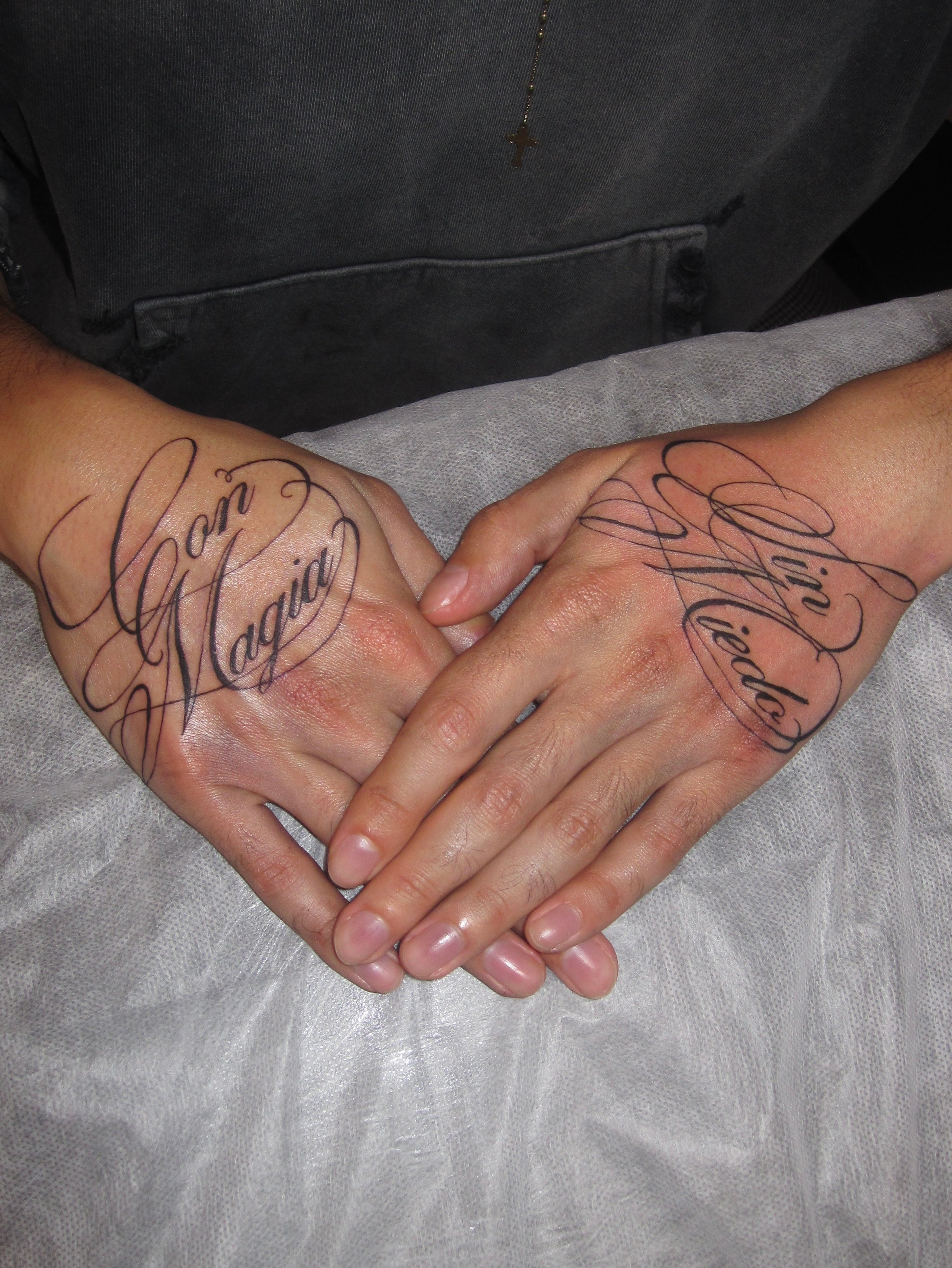 Two hands with Calligraphy script tattoos 
